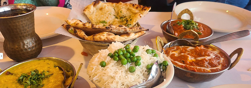 A traditional clay tandoor oven and an assortment of rich Indian vegetarian curries, spinach Saag, and whole wheat roti bread served at Tandoori Grill in Long Beach.
